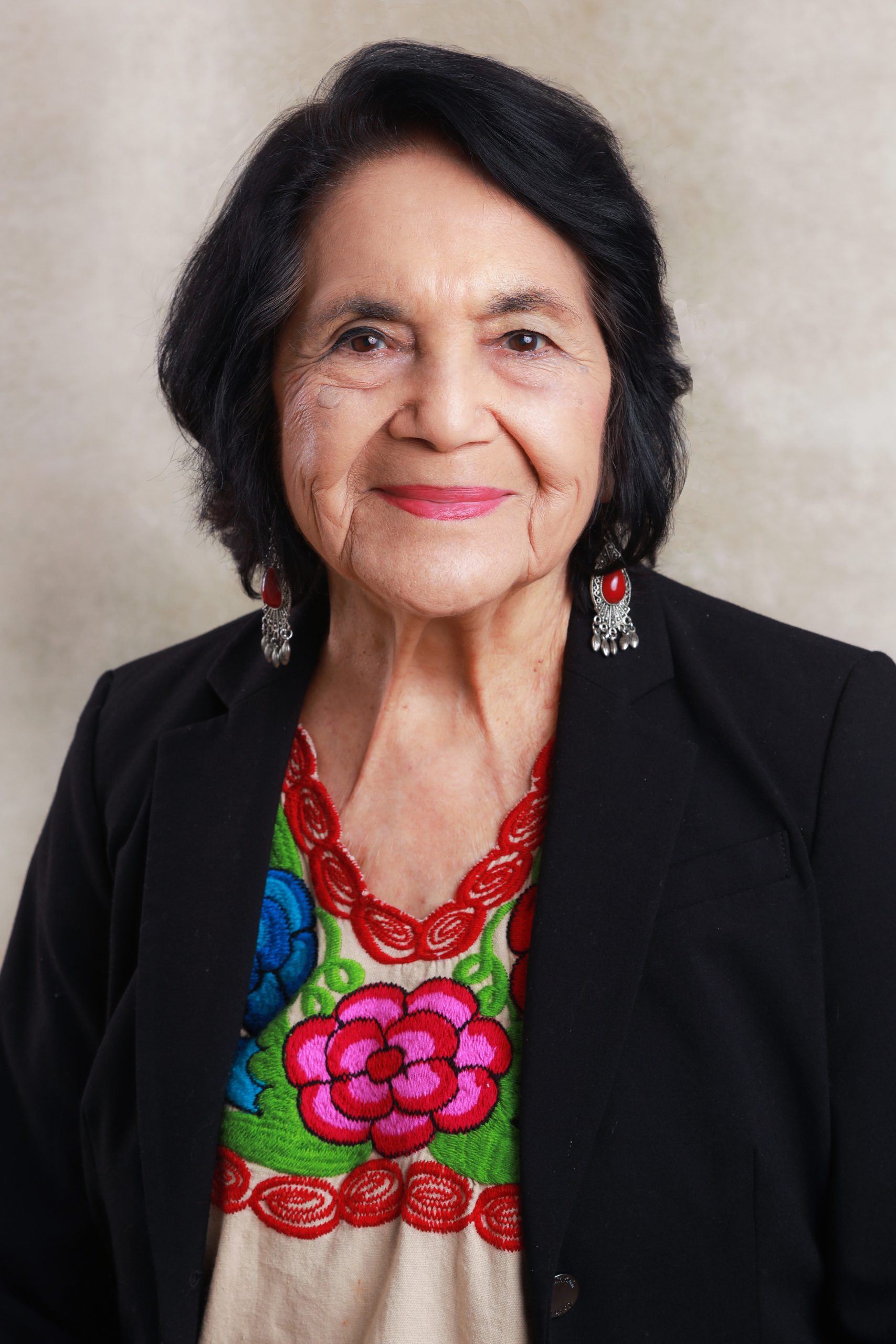 Dolores Huerta in a black blazer and a huipil.